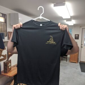 Someone displays the Import placeholder for 13533, a black T-shirt with a small "Don't Tread on Me" front design.