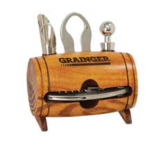 A wooden wine accessory holder labeled "Grainger" with a corkscrew, bottle stopper, and foil cutter.