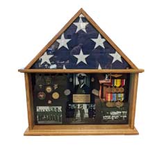 A wooden display case holds a folded American flag, medals, photos, and military memorabilia.