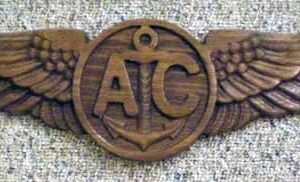 Import placeholder for 1357: Wooden badge with outstretched wings, anchor, and "A" and "C" in the central circle.