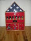 Import placeholder for 449: A shadow box display case with a folded flag, medals, insignias, and nameplates on wood floor.