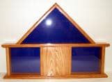 Import placeholder for 549: Wooden display case with blue-tinted triangular glass back and center sliding wooden door.