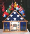Import placeholder for 950: Wooden display case with a folded American flag, medals, trophies, and international flags on top.